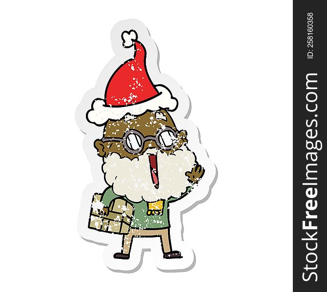 Distressed Sticker Cartoon Of A Joyful Man With Beard And Parcel Under Arm Wearing Santa Hat