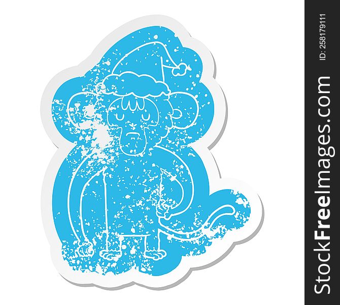quirky cartoon distressed sticker of a monkey scratching wearing santa hat