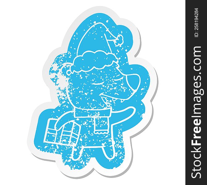 Cartoon Distressed Sticker Of A Bear With Present Wearing Santa Hat