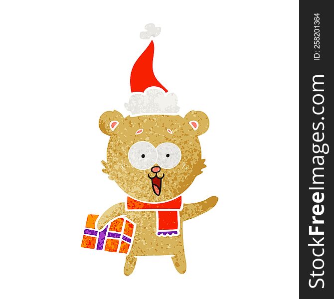 laughing teddy  bear with christmas present wearing santa hat