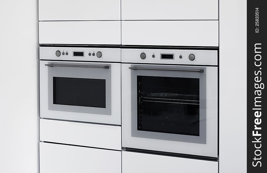 Modern ovens integrated in contemporary white kitchen. Modern ovens integrated in contemporary white kitchen