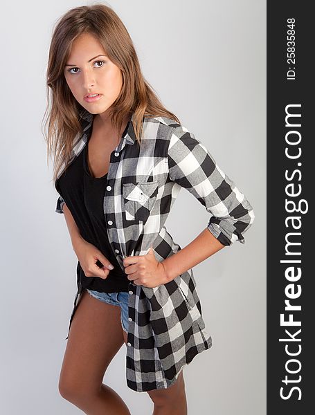 An image of an attractive teenage girl in a flannel shirt and jean shorts. An image of an attractive teenage girl in a flannel shirt and jean shorts