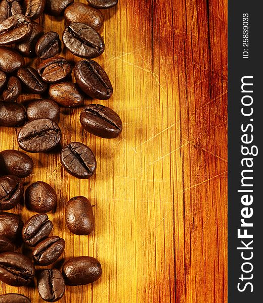 Coffee beans on the wooden desk as food background