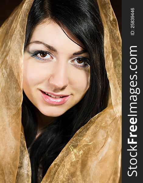 Portrait of young beautiful woman folding brown fabric round her head