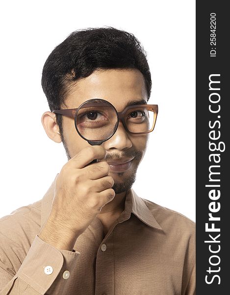 Funny young man looking through magnifying glass, isolated on white. Funny young man looking through magnifying glass, isolated on white