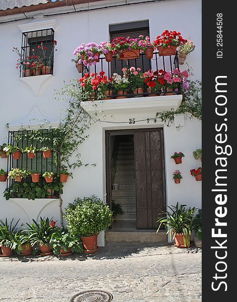 Typical Andalusian house, with flower pots and window on the facade and. Typical Andalusian house, with flower pots and window on the facade and