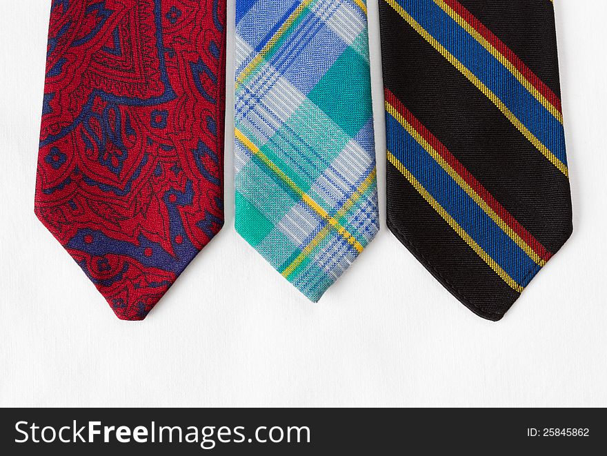 Neckties of various colors with a white cloth as background. Neckties of various colors with a white cloth as background