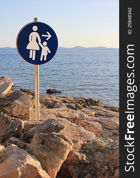 Woman and child walking direction - seaside path traffic sign. Woman and child walking direction - seaside path traffic sign