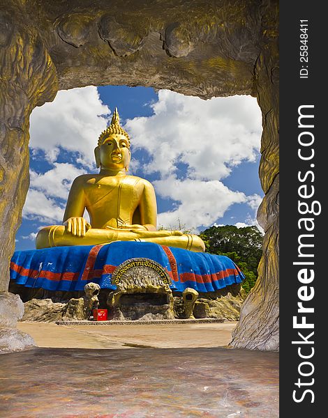 Big Golden Buddha statue with blue sky at tham khao tao temple,thailand