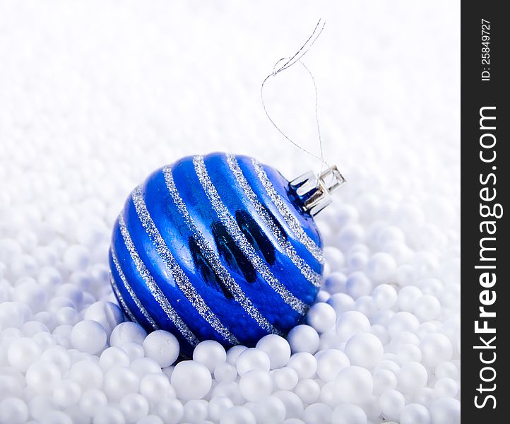 Dark blue fir-tree toy lies in white marbles