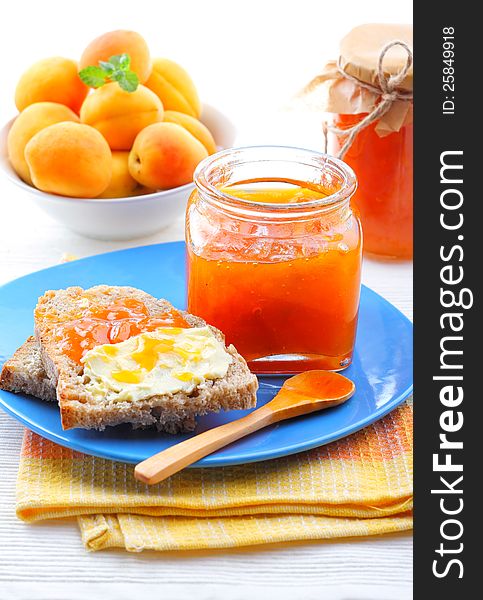 Apricot jam in jar, fresh fruits with bread and butter