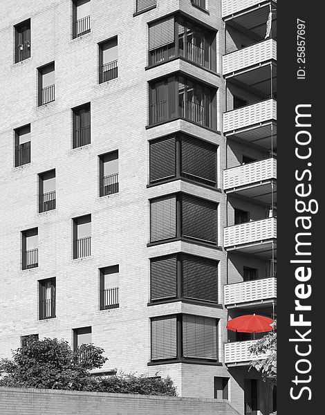 Artistic architectural view in black and white with block of flats with red umbrella