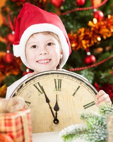 Kid In Santa`s Hat Holding Vintage Clock Royalty Free Stock Photos