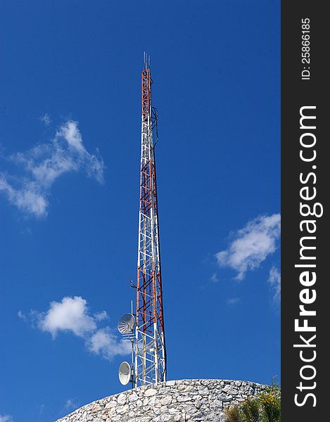 Large communications tower for radio, television, telephone and microwave relaying.Radio Communications Tower with blue sky and cloud background. Large communications tower for radio, television, telephone and microwave relaying.Radio Communications Tower with blue sky and cloud background.