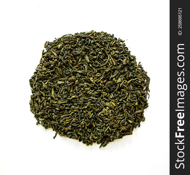 Dried green tea on a white background, close-up photo.