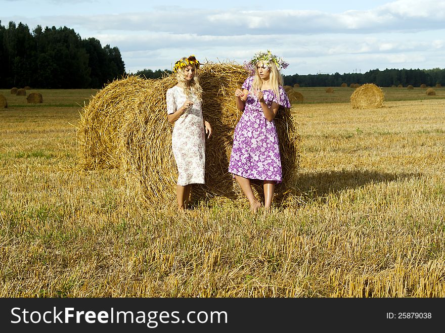 Beautiful girls on the field near the haystacks. Beautiful girls on the field near the haystacks