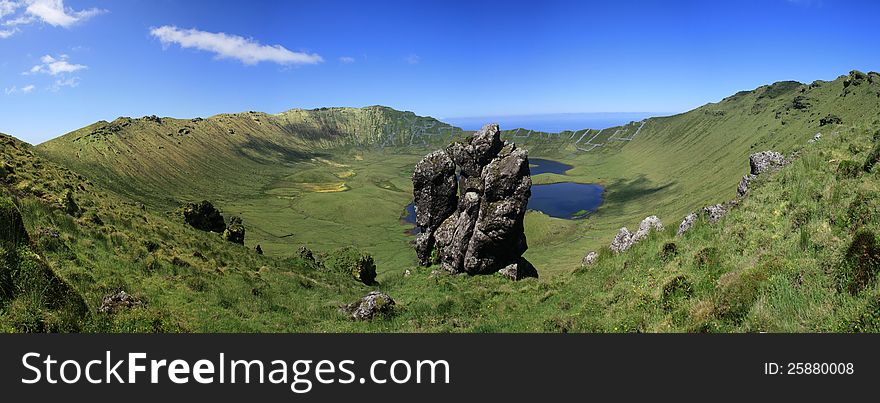 A panoramic view from Caldeirão Lake and the crater of the eruption on the Island of Corvo. In background the Atlantic Ocean. A panoramic view from Caldeirão Lake and the crater of the eruption on the Island of Corvo. In background the Atlantic Ocean.