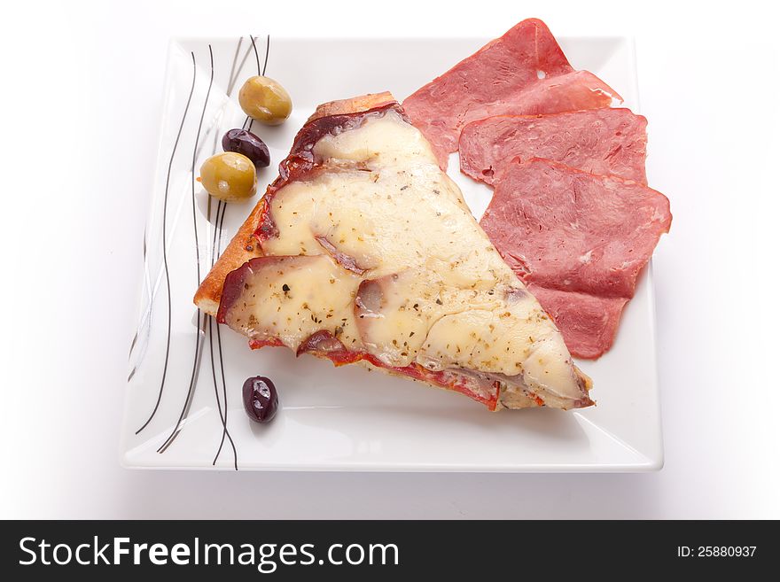 Pizza slice with olive and salami on a plate on white