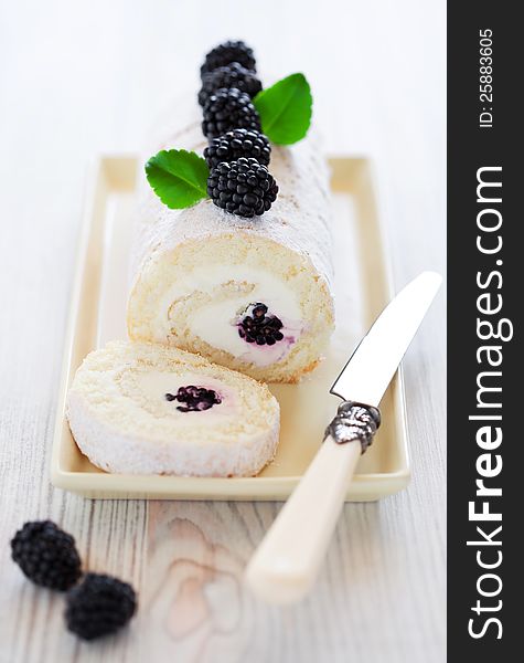 Swiss roll with cream cheese and blackberry, selective focus