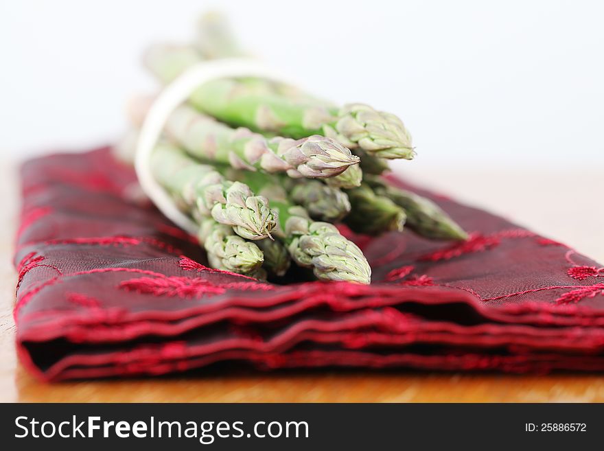 Green asparagus on red napkin. Shallow dof