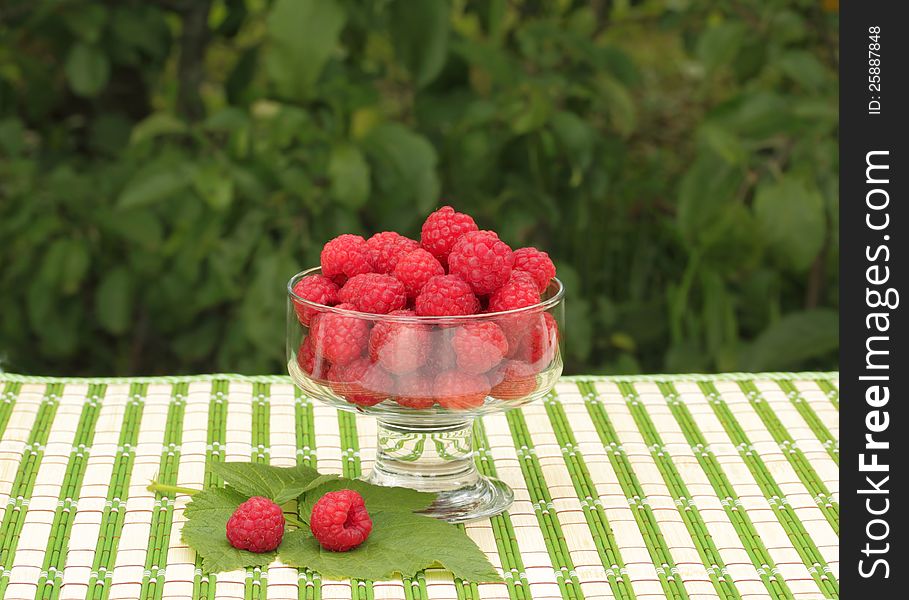 Raspberries in a glass bowl in the garden. Raspberries in a glass bowl in the garden