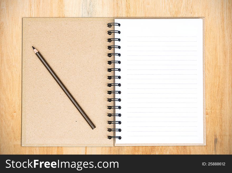 White notebook with frangipani flower on the wood