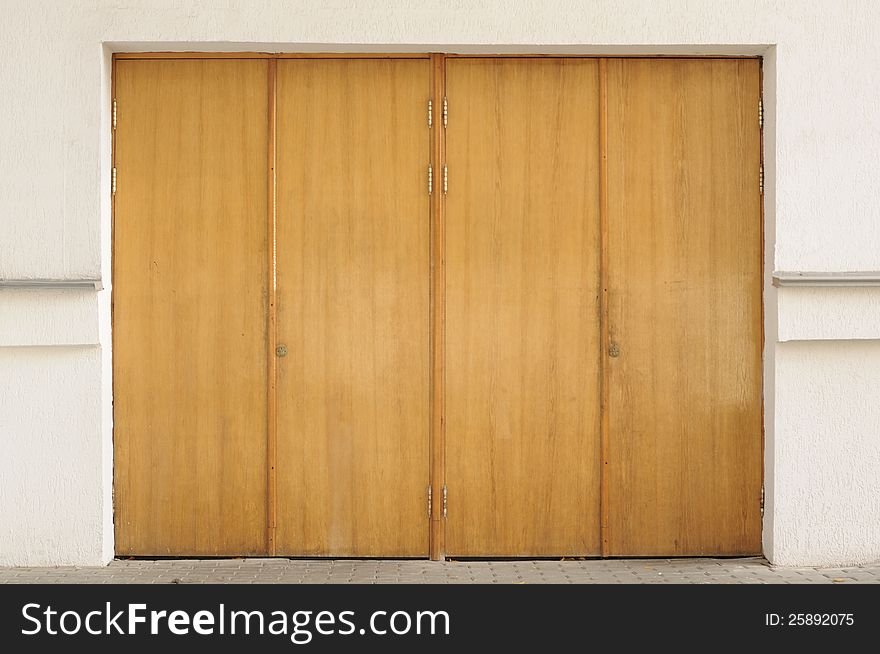 Old closed wooden entrance doors in the exterior of a building. Old closed wooden entrance doors in the exterior of a building