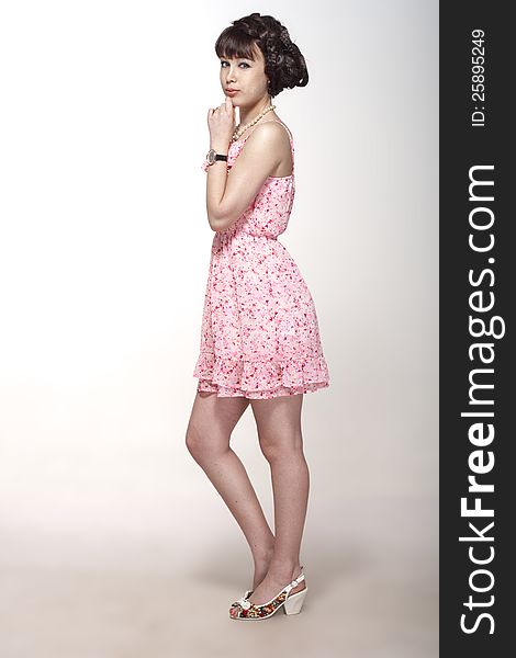 Beautiful girl posing in a pink dress and sandals. Beautiful girl posing in a pink dress and sandals