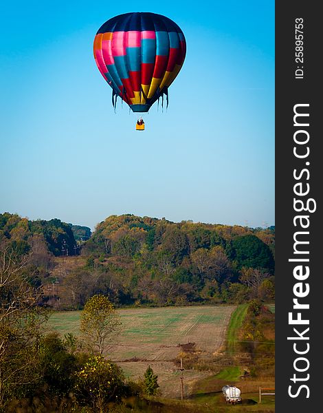 Hot air balloon hanging weightlessly and peacefully over beautiful north carolina landscaped farmland. Hot air balloon hanging weightlessly and peacefully over beautiful north carolina landscaped farmland
