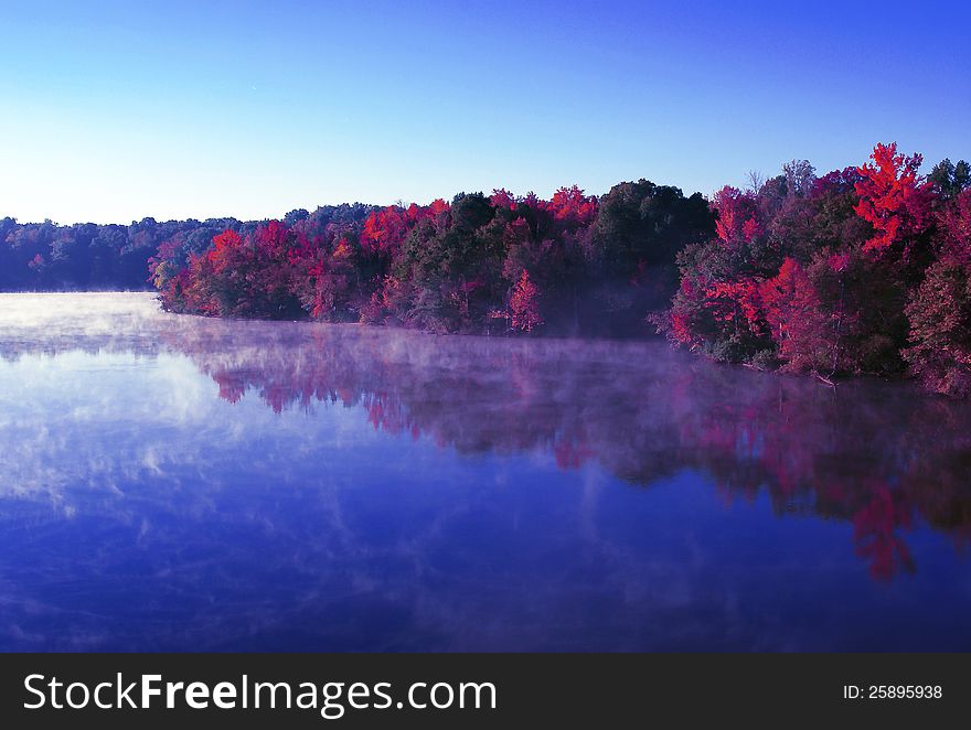 Image taken from highway overpass over the river overlooking these beautiful tree colors reflecting of calm early morning waterflow. Image taken from highway overpass over the river overlooking these beautiful tree colors reflecting of calm early morning waterflow