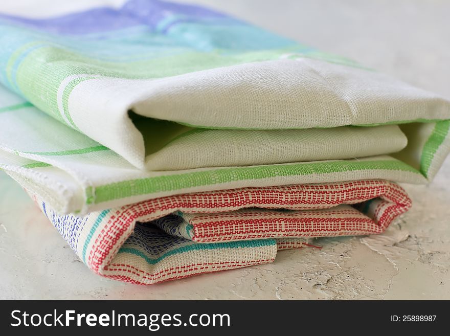 Pile of colourful stripped kitchen  towels on metallic surface (shallow DOF). Pile of colourful stripped kitchen  towels on metallic surface (shallow DOF)