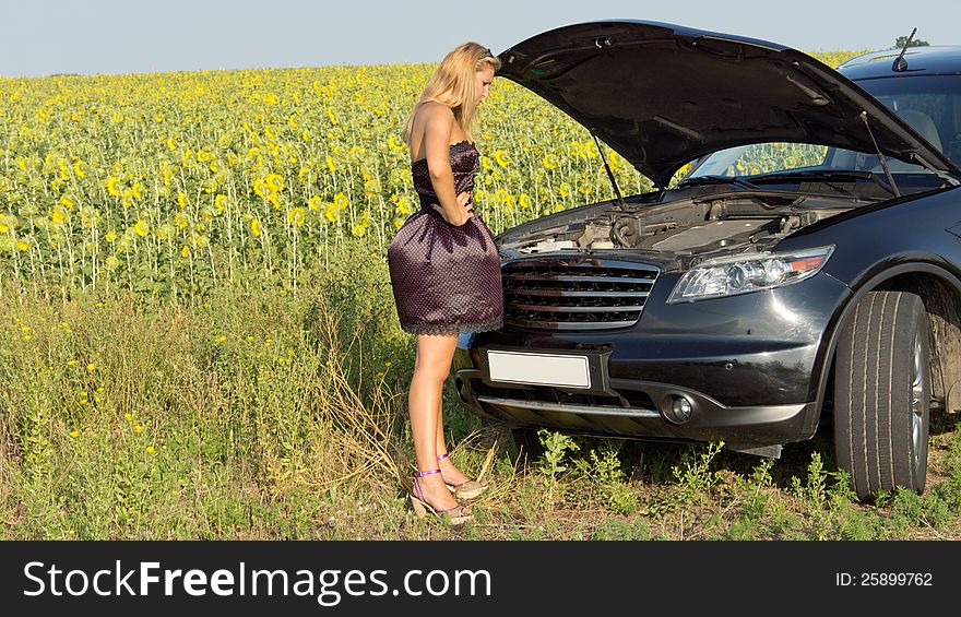 Bemused woman looking at car engine