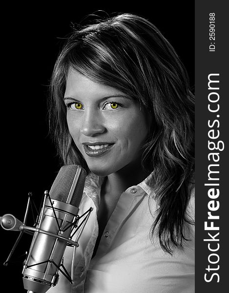 Beautiful woman with vintage microphone over a black background.