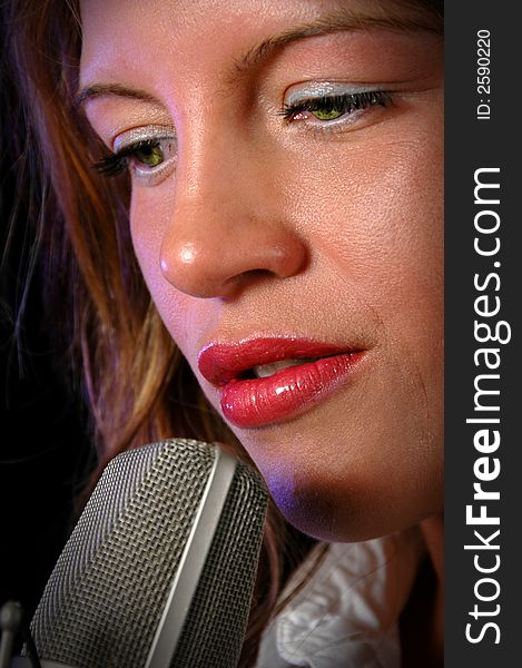 Beautiful woman  singing with nicrophone in close-up view. Beautiful woman  singing with nicrophone in close-up view