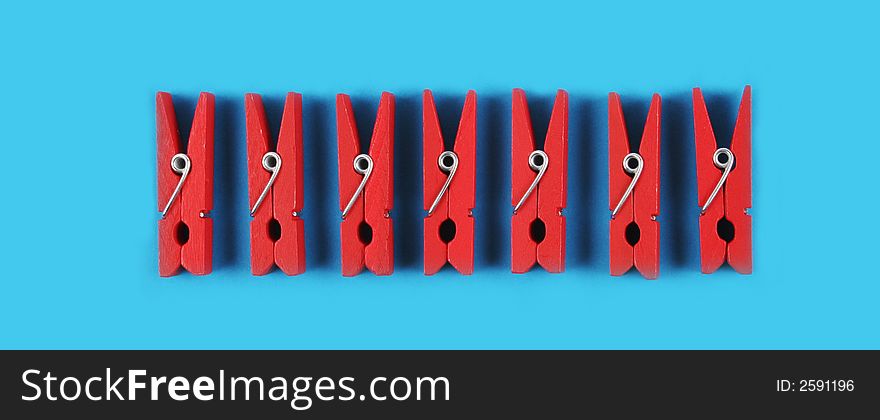 Red pegs isolated on a blue background