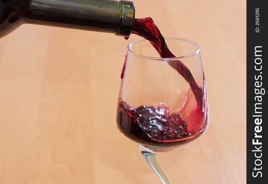 The red wine flowing from a bottle in a glass