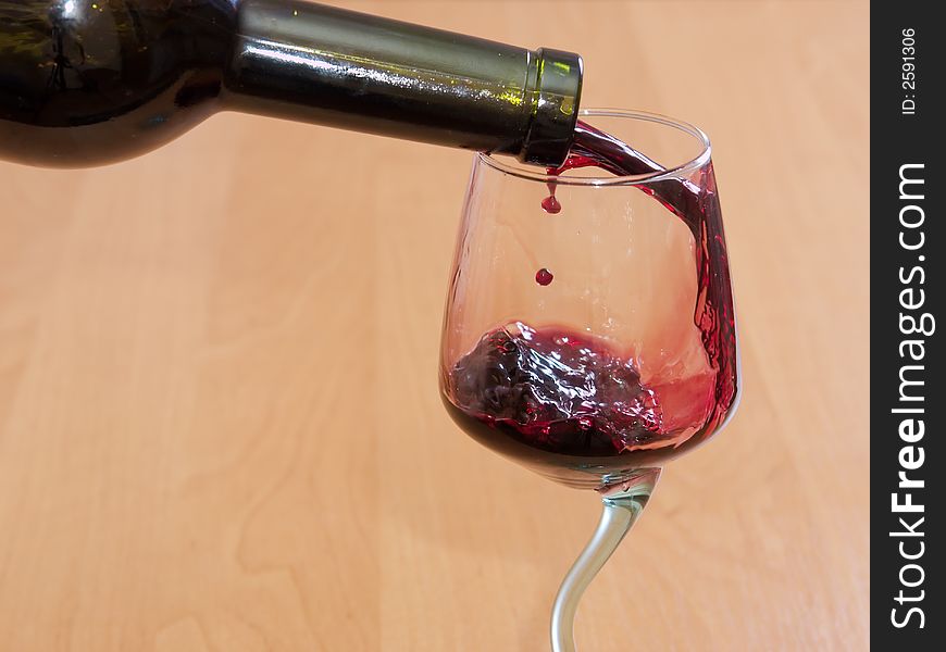 The red wine flowing from a bottle in a glass