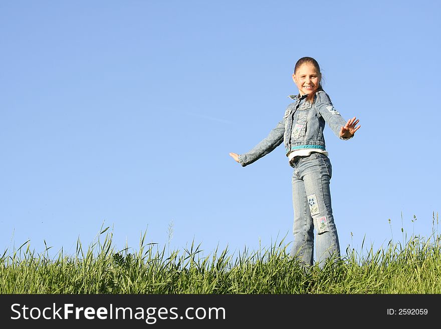 Girl costs on a grass on a background of the blue sky. Girl costs on a grass on a background of the blue sky