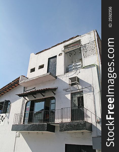 An old grey stucco home on a cliff overlooking ocean. An old grey stucco home on a cliff overlooking ocean