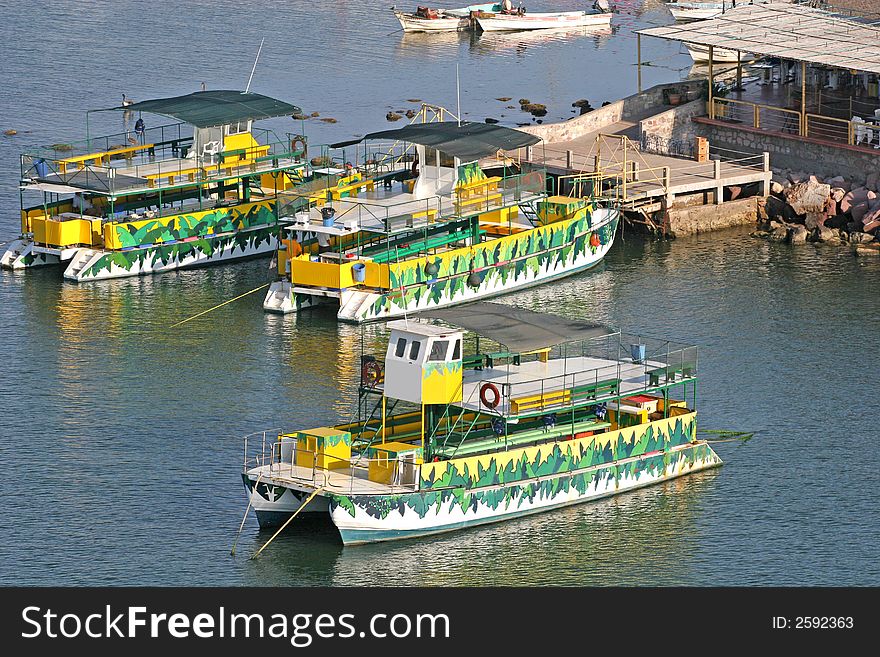 Colorful green and yellow party boats waiting for passengers. Colorful green and yellow party boats waiting for passengers