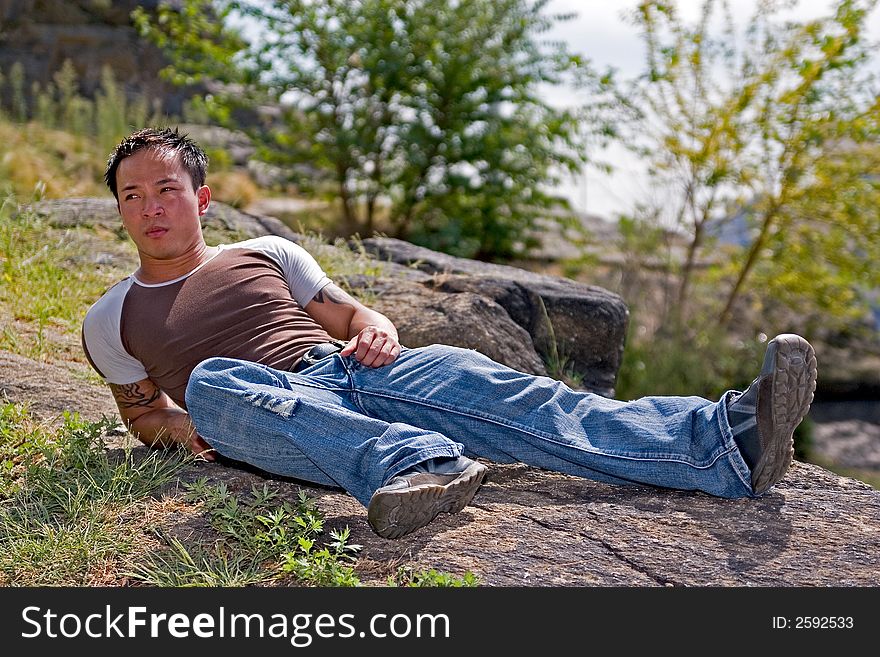 A young asain man relaxing at the park. A young asain man relaxing at the park