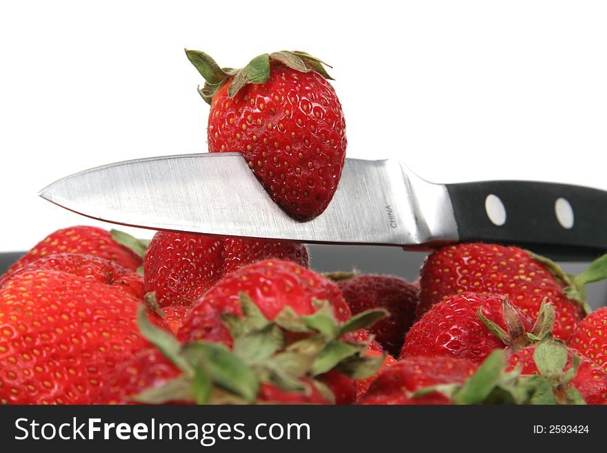 Strawberries with metal knife with white background