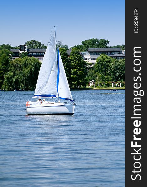 Small white yacht sailing on the lake on sunny day. Small white yacht sailing on the lake on sunny day