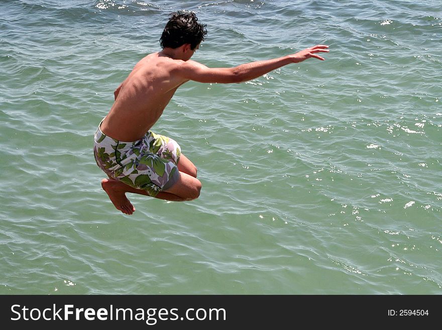 Boy jumping into te ocean. Boy jumping into te ocean