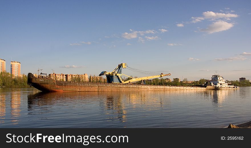 A photo of a barge get unloaded. A photo of a barge get unloaded