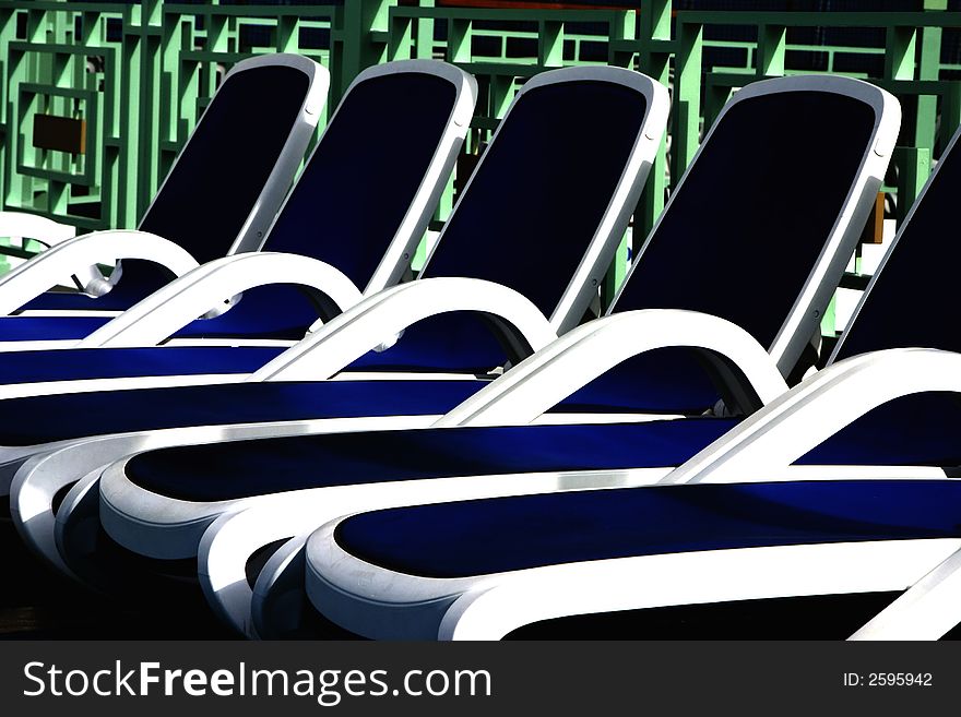 Row of lounge chairs on a cruise ship deck at sunrise. Row of lounge chairs on a cruise ship deck at sunrise