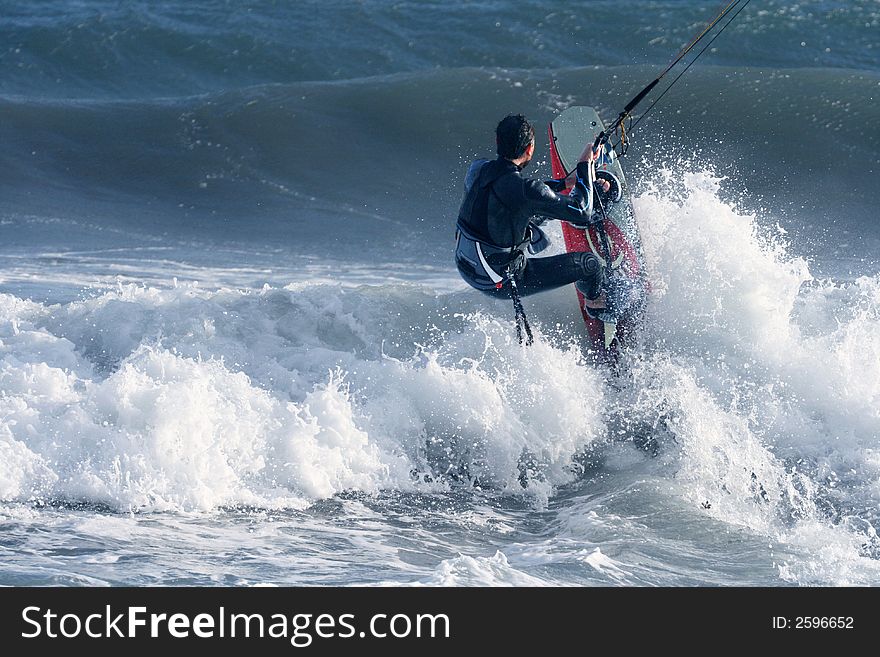 A kitesurfer in andalusia fights agains the waves. A kitesurfer in andalusia fights agains the waves