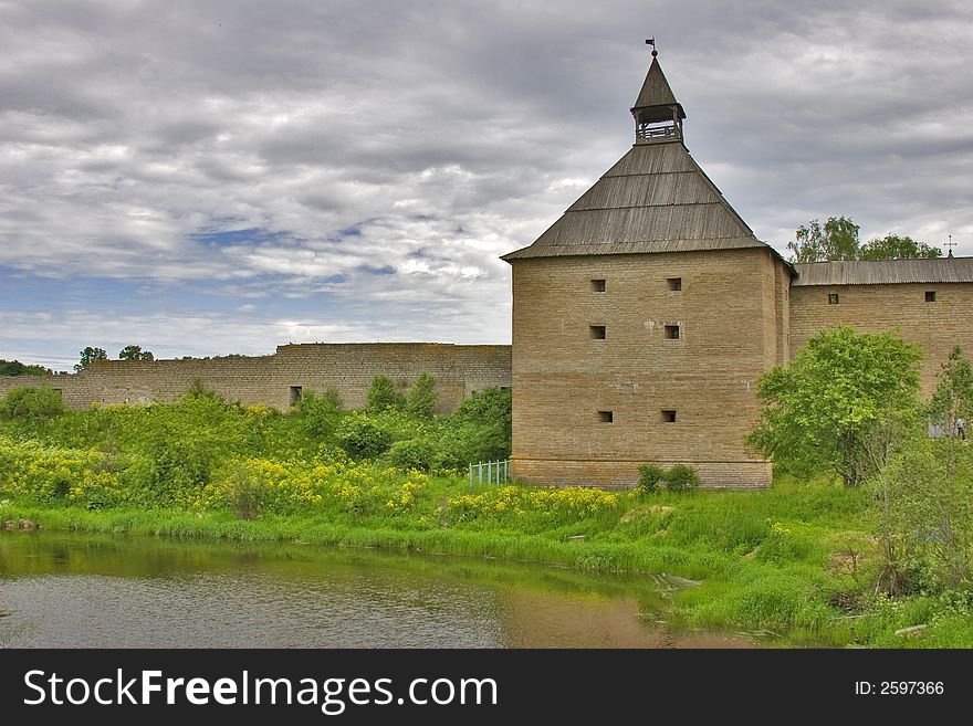 Medieval castle and green trees under sky with clouds. Medieval castle and green trees under sky with clouds