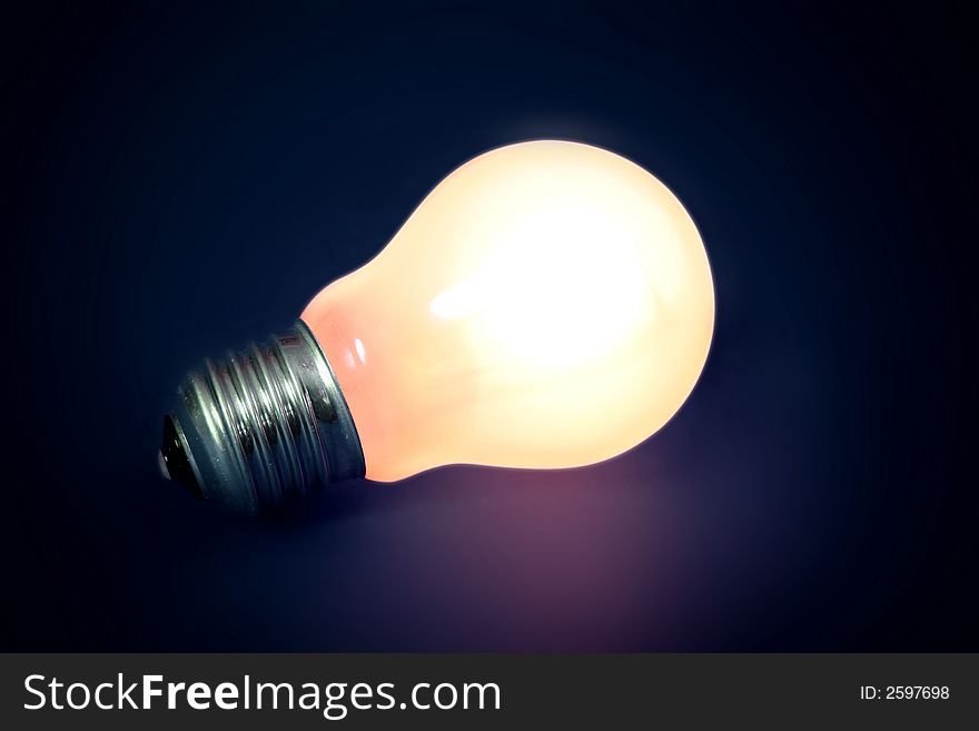 Light bulb isolated over a dark blue background