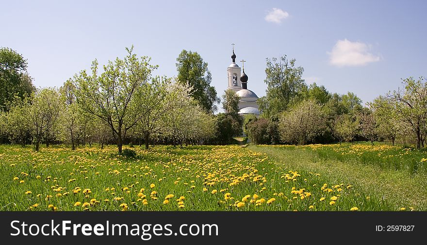 A photo of a chirch among trees and flowers in blossom. A photo of a chirch among trees and flowers in blossom